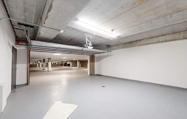 A large, empty industrial space with a concrete floor and ceiling at One West Drive Apartments, Excelsior, MN