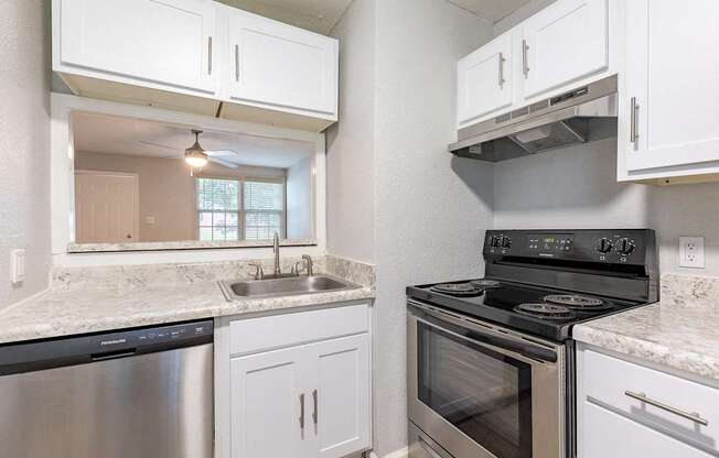 A kitchen with white cabinets and a stainless steel dishwasher.