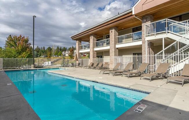 Apartments for Rent in Spokane WA - Canyon Bluffs - Outdoor Pool with Concrete Pool Deck and Lounge Chairs