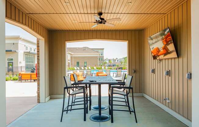 a patio with a table and chairs and a ceiling fan