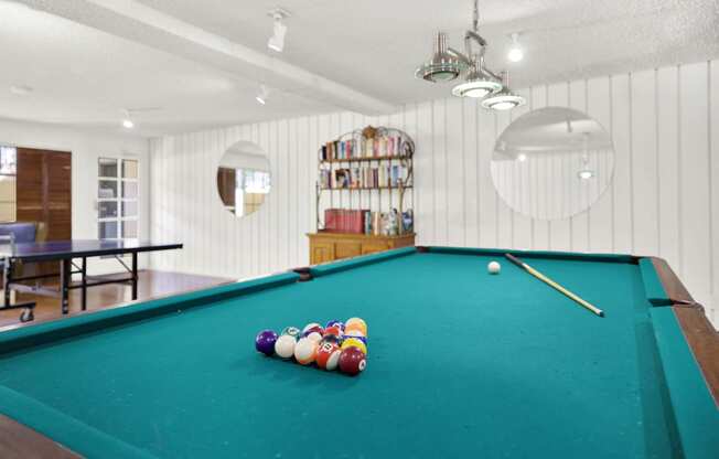 a pool table in a room with balls on it at Camino de Oro Apartments, Torrance, CA