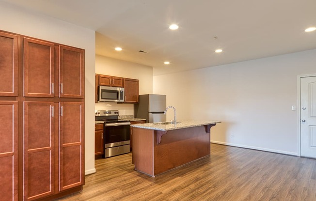 a kitchen with wooden cabinets and a granite counter top and a refrigerator