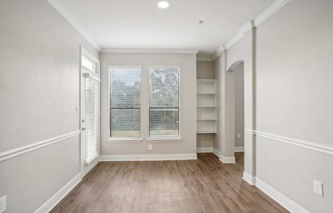 the living room of a new home with white walls and wood flooring  at The Verandah, Austin, TX, 78726