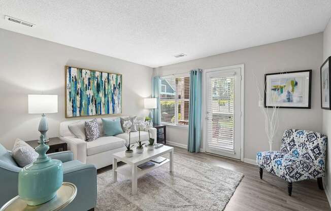 A living room with a white couch, a coffee table, and a painting on the wall.
