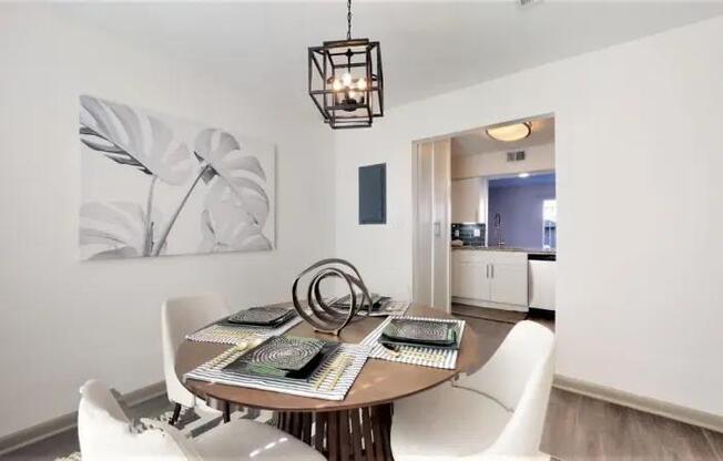 A dining room with a wooden table and white chairs.