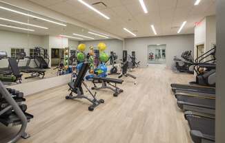 A gym with a variety of equipment including treadmills, weights, and exercise machines at The Pennsylvanian Apartments, Pittsburgh, 15222