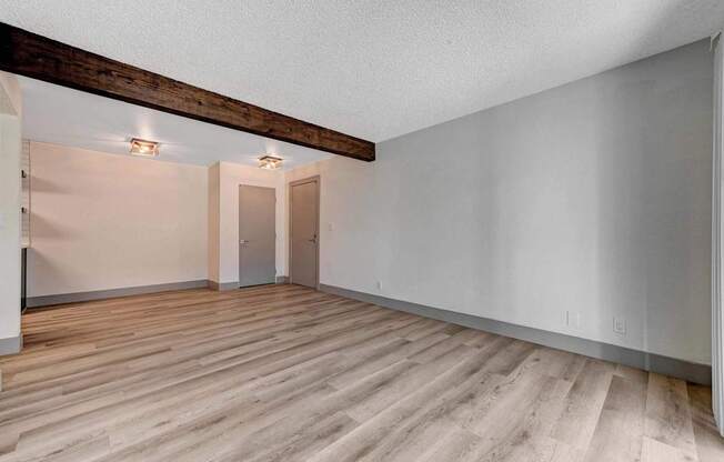 A room with wooden flooring and white walls.