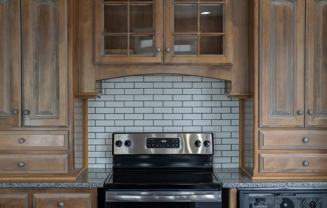 a kitchen with wood cabinets and a black stove top oven
