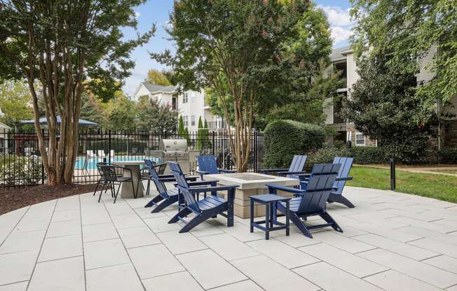 an outdoor patio with blue chairs and tables and a pool