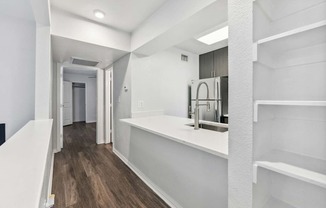 a white kitchen with a sink and a refrigerator