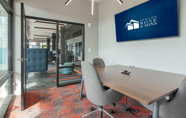 a conference room with a table and chairs and a sign on the wall