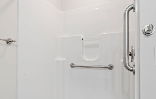 A white bathroom with a walk in shower.