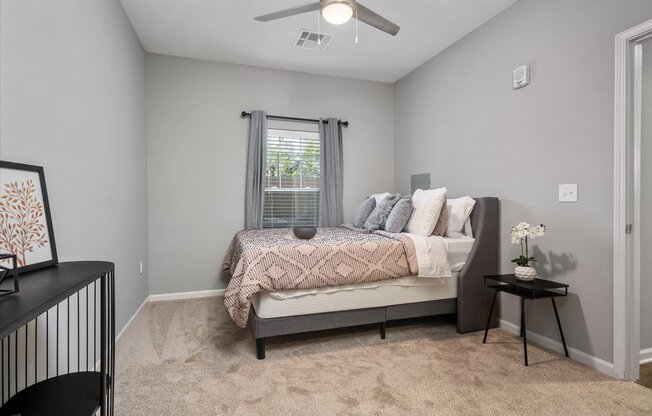 a bedroom with a bed and a ceiling fan