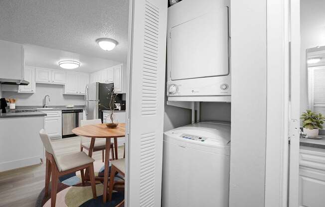 A white fridge in a kitchen with a table and chairs.