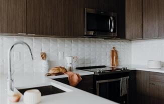 a kitchen with a sink a stove and a microwave