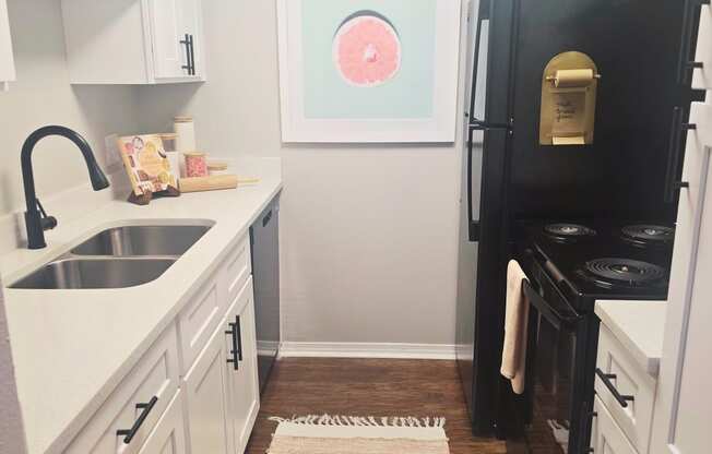 kitchen with white cabinets and a black refrigerator