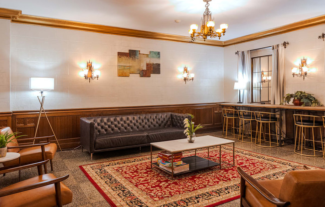 A living room with a grey sofa and a chandelier.