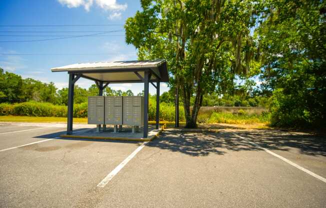 a bus stop in a parking lot with trees