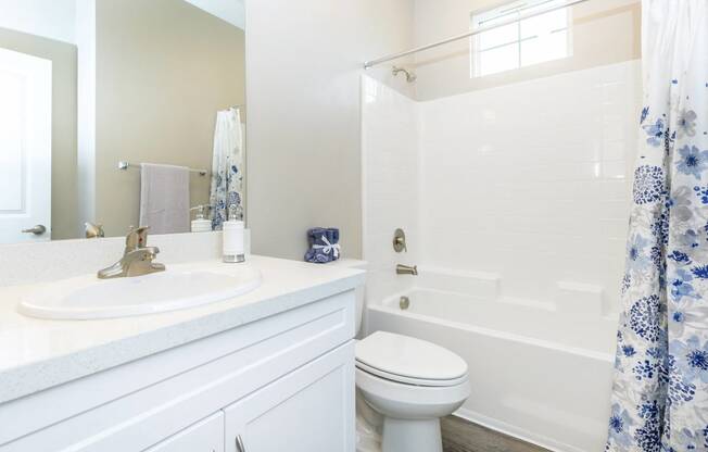 a white bathroom with a shower and a sink and a toilet