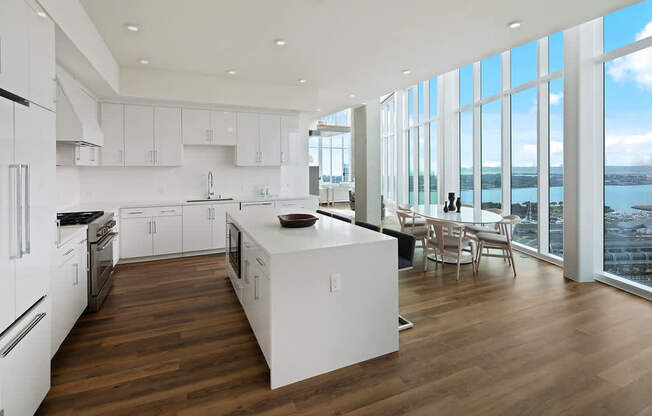 A modern kitchen with white appliances and wooden floors.
