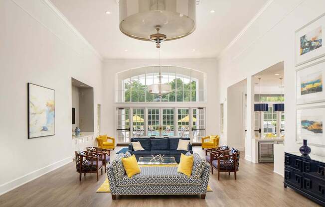 a living room with a couch and chairs and a large window