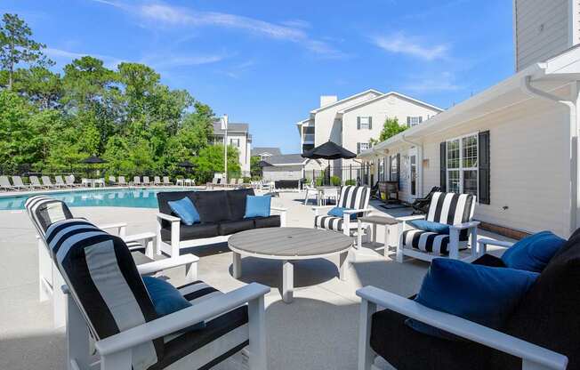 A patio with black and white striped chairs and a round table.