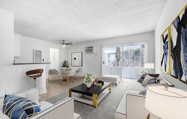 a living room with white furniture and a ceiling fan