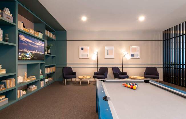 A pool table is in the middle of a room with a blue carpet.