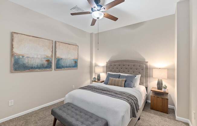 A bedroom with a large bed and a ceiling fan.