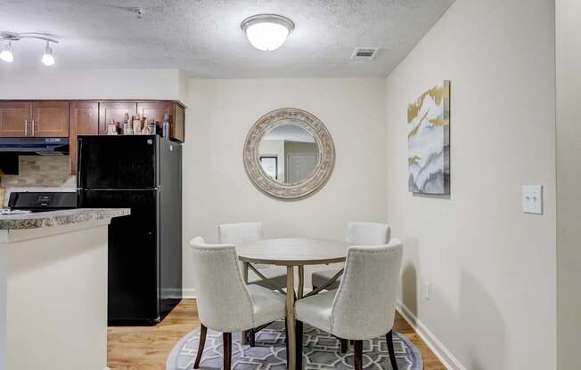 A kitchen with a table and chairs.
