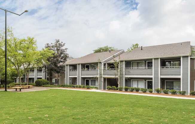 A large grassy area in front of apartment buildings.