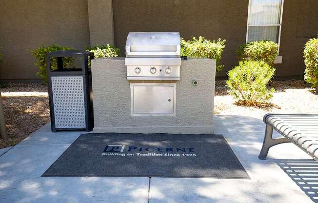 Gas BBQ grill built into a concrete block and trash can