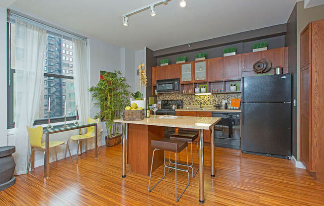 a kitchen with a large island and a stainless steel refrigerator