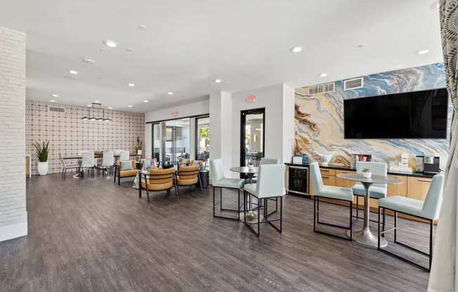 A modern dining area with wooden floors and a mix of white and dark chairs.