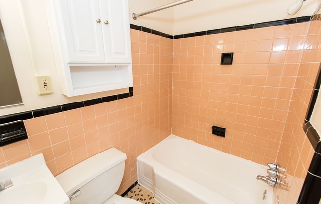 bathroom with tub, toilet, medicine cabinet and tile details at dupont apartments in washington dc