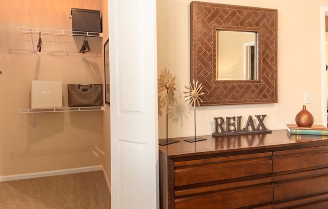 a walk in closet with a dresser and mirror