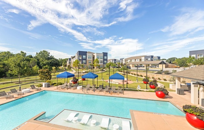 A pool with a slide and a building in the background.