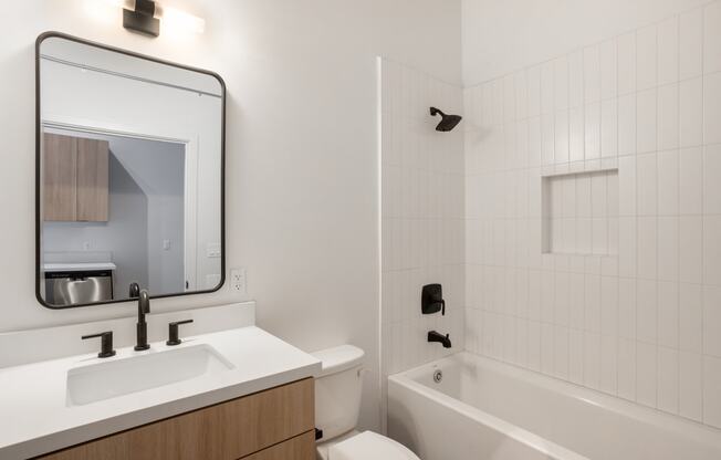 Santa Fe Art Colony bathroom with a sink and a tub and a mirror