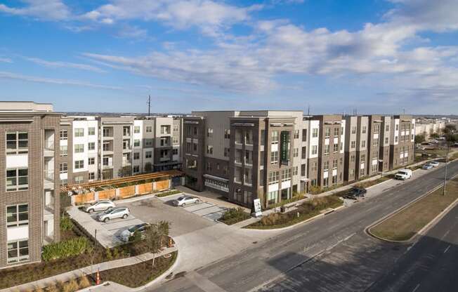 an aerial view of an apartment complex with a parking lot and a street at Arise Riverside, Texas