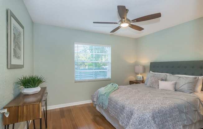 the master bedroom has a large bed and a ceiling fan