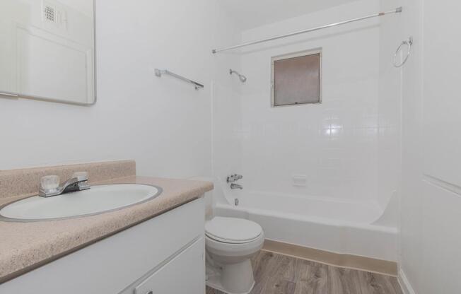 A white bathroom with a sink, toilet, and bathtub.