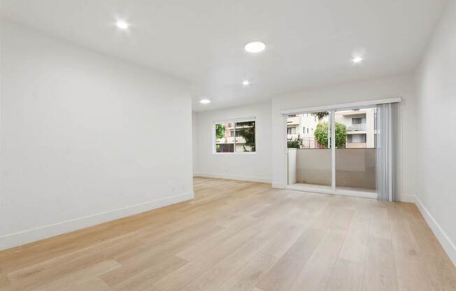 A room with wooden flooring and white walls.