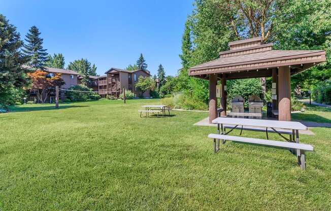 a picnic table and gazebo in a grassy area with apartment buildings in the at Lincoln Village Apartments, Washington, 99208