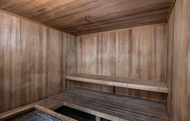 a wooden sauna with two benches and a grate
