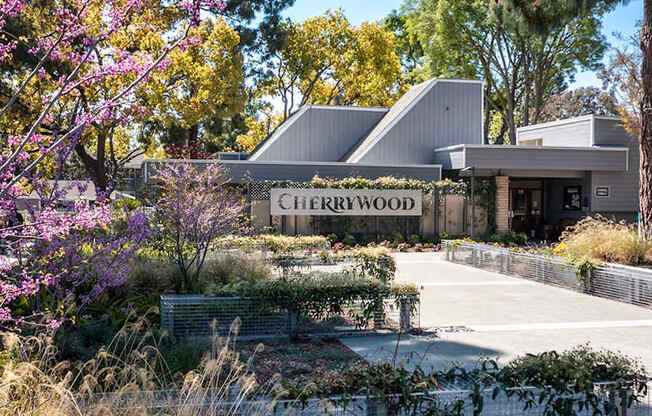 Cherrywood sign in front of a building with trees and bushes.