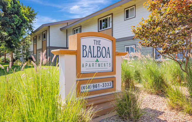 A sign for The Balboa Apartments stands in front of a building.