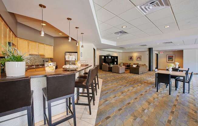 A dining area with a bar, tables, and chairs.
