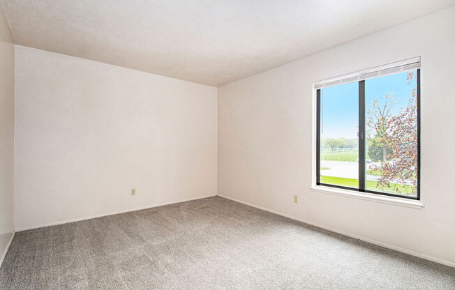 bedroom with a large window and carpeting