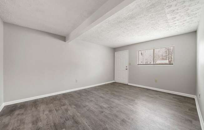 an empty living room with wood flooring and a white door