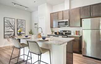 A kitchen with a table and chairs in front of a stove.